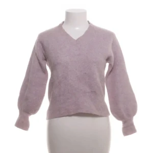 Stickad tröja Visual Clothing Project - Superfin stickad tröja från Visual Clothing Project i storlek S. Tröjan har v-ringad hals och ballongärmar som ger en chill vibe. Materialmix med alpacka, ull och polyamid gör den både mjuk och fluffig. Perfekt att styla med jeans eller kjol för en snygg look.