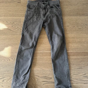 Replay grå jeans Thad slim fit - Säljer ett par gråa Replay Thad jeans med snygg tvätt. Jeansen har slim fit passform och raka ben, med Replay-logga på insidan och bakficka. Perfekta för dig som gillar stilrena och bekväma jeans.