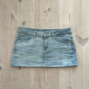 Blå lågmidjad jeanskjol  - Ljusblå lågmidjad jeanskjol från Yessica i storlek 38. Tvärs över midjan är det 40 cm och den är 29 cm lång (låmgs med sidan). Fint skick. Passar S och M. Använd gärna köp nu!