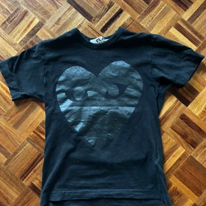 Cdg Tshirt - Svart Cdg tshirt med hjärt tryck på både fram och baksida. Skick: Knappt använd, som ny. Nypris: ≈1000kr. Mitt pris: 499kr Storlek: Small, passar 170-175 ungefär. Meddela vid frågor!