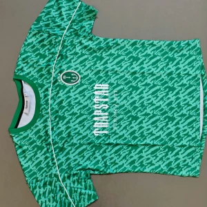 Grön camo fotbollströja från Trapstar - Snygg grön fotbollströja från Trapstar med camouflagemönster och vita tryck på både fram- och baksidan. Tröjan har korta ärmar, rund hals och är gjord i ett lätt, ventilerande material som passar perfekt på planen. Coola detaljer med logga och nummer 22 på ryggen.