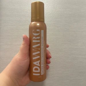 IDA WARG Tinted Self-Tanning Mousse - Säljer en tinted self-tanning mousse från IDA WARG i en snygg brun och guldig flaska på 150 ml. Moussen är vegansk och ger en medium till mörk färg. Perfekt för dig som vill ha en solkysst look utan att sola. Är testad