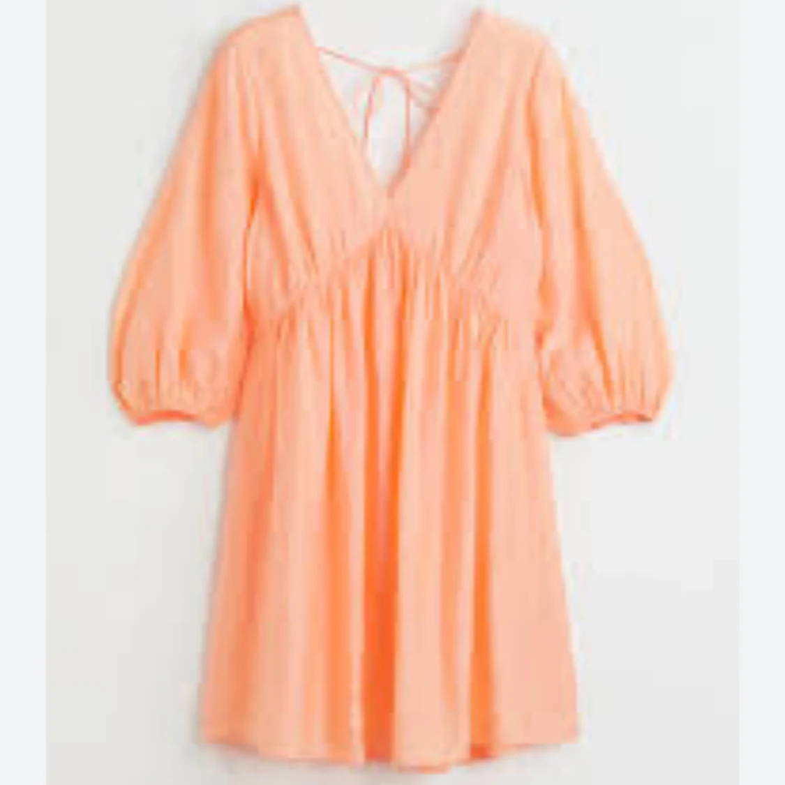 Persikofärgad kort klänning med v-ringning