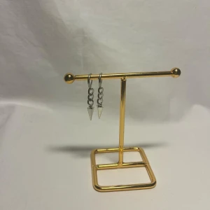 Silvriga örhängen med kedja och spets - Säljer ett par coola silvriga örhängen med kedjor och spetsiga hängande detaljer. Perfekta för dig som gillar edgy och minimalistisk stil. Passar till både streetwear och mer stilrena outfits.