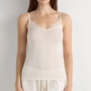 Vit linnetopp med spetsdetalj - Säljer en ljusvit linnetopp med smala axelband och v-ringad hals med fin spetskant. Toppen är ärmlös och har en mjuk, tunn känsla som passar perfekt till chill outfits. Enkel och stilren design som är lätt att matcha. Jag har endast testat tröjan. Pris går att diskutera vid snabb affär🥰