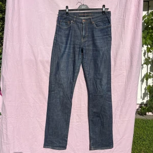 Blå jeans Boomerang Denim Björn W31 L32 - Snygga blå jeans från Boomerang Denim Björn med klassisk femficksdesign och kontrastsömmar. Jeansen har rak passform och normal midja, tillverkade i slitstarkt denimtyg. Perfekta för en avslappnad och stilren look.