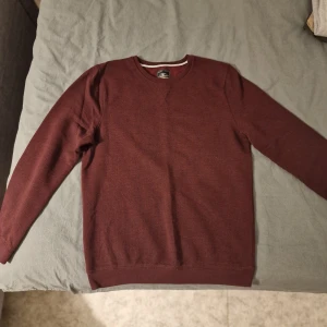 Vinröd tröja från Hampton Republic - Snygg vinröd tröja från Hampton Republic i storlek M. Tröjan har rund hals och långa ärmar, perfekt för dig som gillar stilrena och klassiska plagg. Materialet känns mjukt och skönt mot huden, och färgen är riktigt djup och snygg.