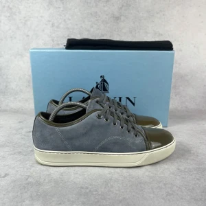 Lanvin DBB1 cap toe sneaker - – Condition: 8/10  - Size: 40/UK6  – What is included: Only the sneakers  – Retail price: 5000 + SEK  Please note that Lanvins fit big and our recommendation is to go one size down