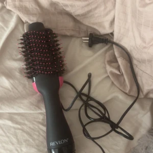 Revlon hårfönborste svart/rosa - Säljer en elektrisk hårfönborste från Revlon i svart med rosa detaljer. Borsten har täta borststrån med rosa toppar och är rundad för enkel styling och volym. Perfekt för att föna och forma håret snabbt och smidigt. Säljer då jag har en Björn Axén också. Håret tar jag självklart bort innan jag fraktar! ❤️