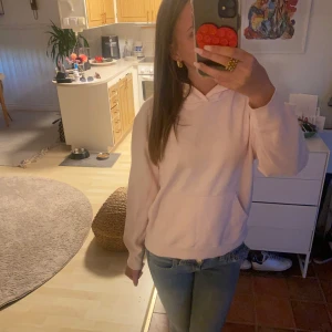 Ljusrosa hoodie från Baz - Säljer en ljusrosa hoodie från Baz i storlek 150/160. Tröjan har huva, lång ärm och en klassisk känguruficka framtill. Perfekt för chill dagar och enkel att matcha med jeans eller mjukisbyxor. Mjuk och skön bomullskänsla.