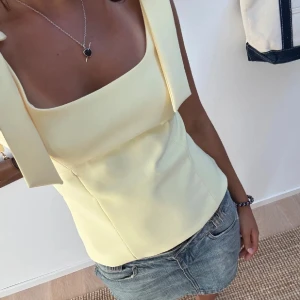 Gul topp med rosett band - Säljer denna fina gula topp somnar köpt från Zara. Endast använd vid ett tillfälle. Nypris 329 kr. Lånade bilder 