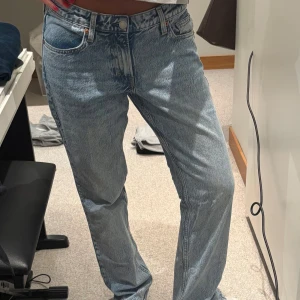 H&M ljusblå jeans straight fit - Säljer ett par klassiska h&m jeans i ljusblå tvätt med raka ben och fem fickor. Jeansen har hög midja och är tillverkade i slitstarkt bomullsjeans. Perfekt för dig som gillar en chill och tidlös look.