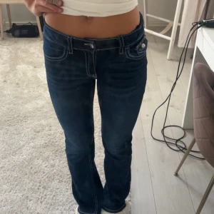 Mörkblå bootcut jeans Gina Tricot - Mörkblå jeans från Gina Tricot med bootcut passform och låg midja. Snygga kontrastsömmar och fickor med knappar, aldrig använda och storlek 170💗fråga så mycket ni behöver!!nypris 360kr! Pris kan diskuteras vid snabb affär💞
