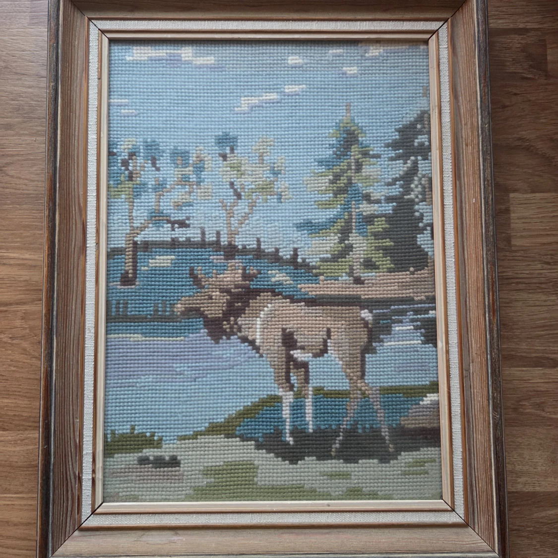 Tavla med motiv av en älg i naturen, broderad 