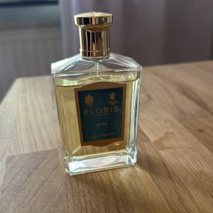 Floris No 89 Eau de Toilette 100 ml - Exklusiv parfym från Floris London, No 89 Eau de Toilette. Flaskan är rektangulär i klart glas med en lyxig guldfärgad kork och etikett i blått och guld. Innehållet är ljust gyllene. Perfekt för dig som gillar klassisk och elegant doft. Skulle säga att det är cirka 90 milliliter kvar :)