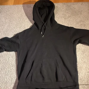 Svart hoodie - Säljer en svart hoodie med stor huva och snörning. Helt ny så väldigt bra skick.