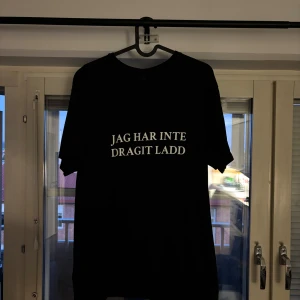 (Jag har inte dragit ladd) Svart t-shirt - Svart t-shirt med vit text på bröstet där det står 'JAG HAR INTE DRAGIT LADD'. Skön och enkel stil som passar till det mesta. Materialet är bomull och modellen är normal i passformen.