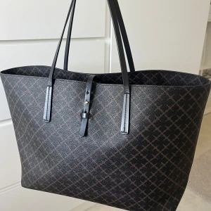 By Maline Birger - Stilren och rymlig shoppingväska i svart med mörkbrunt rutigt mönster.   Skriv fler detaljer och priset går att diskutera💗💗💗💗