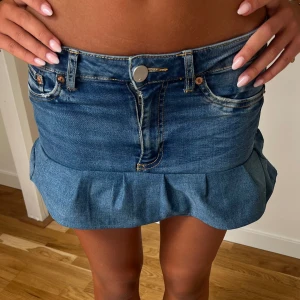 Jeanskjol med volang - Superfin blå jeanskjol med volang längst ner och klassiska fickor både fram och bak. Kjolen har en kort modell och stängs med knapp och dragkedja. Perfekt för dig som vill ha en trendig och avslappnad look. Sydd själv❤️ skitsnygg
