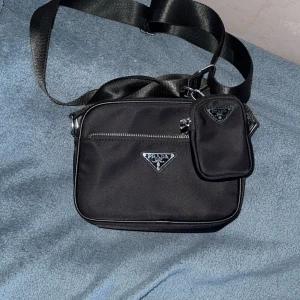 Prada axelremsväska  - Fin Prada axelremsväska som passar utmärkt på sommar men även höst/våt stilren väska med klass.