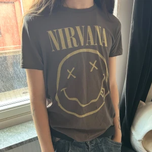 Nirvana t-shirt  -  Nirvana t-shirt. Materialet är mjuk bomull, perfekt för dig som gillar bandmerch. Defekter som småhål lite här och där förekommer därav lägre pris på tröjan:)