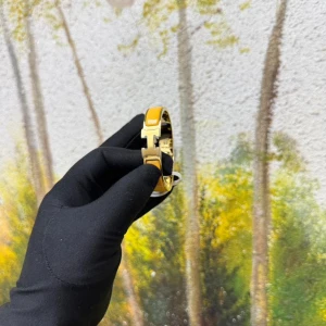 Gult H-armband från Herms - Snyggt armband från Herms i guldtonat metall med gul emalj och ikoniskt H-spänne framtill. Stilren och lyxig design som verkligen sticker ut på handleden. Perfekt accessoar för dig som vill ha något klassiskt men ändå färgstarkt.