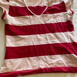 Randig röd och vit topp från Lindex - Säljer en kortärmad topp från Lindex. Storlek 34/36