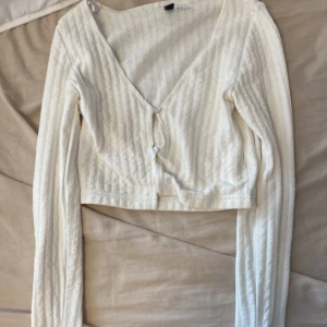 Kofta med knappar - En kofta som även funkar som topp, det är en magtröja fast kofta, aldrig använd men saknar etikett 