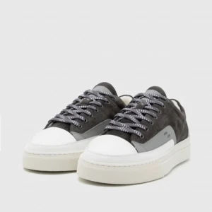 Grå mockasneakers från Filling Pieces - Snygga sneakers i mörkgrå mocka med grå och vita detaljer samt vit platt sula. Skorna har rund tå, snörning med mönstrade skosnören och grå häl med perforerat FP-logo. Perfekt för dig som gillar stilrena och moderna sneakers.