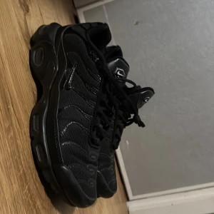 Svarta Nike Air Max sneakers - Svarta Nike Air Max sneakers med chunky sula och snygga detaljer i mesh och syntet. Skorna har snörning och en sportig vibe med diskret Nike-logga på plösen. Perfekta för dig som gillar streetstyle och vill ha bekväma skor med attityd.