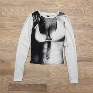 Vit långärmad tröja med tryck - Vit långärmad tröja från SHEIN med ett svartvitt grafiskt tryck på framsidan. Tight passform och tunn, stretchig polyester som sitter snyggt mot kroppen. Perfekt statement-piece 