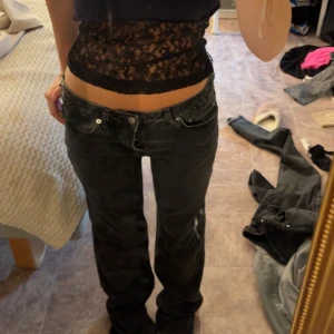 Svarta jeans low waist - Säljer ett par svarta jeans med låg midja och rak passform. Jeansen har klassiska 4 fickor, knappgylf och är i ett slitstarkt jeanstyg. Perfekta för en avslappnad och cool stil.