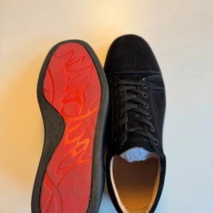 Christian Louboutin skor - Snygga svarta sneakers från Christian Louboutin med den ikoniska röda sulan i storlek 43. Skorna har snörning och är tillverkade i mocka, vilket ger en lyxig känsla. Perfekta för att ge din outfit en exklusiv touch. Allt og tillkommer.OBS priset är inte satt i sten och kan diskuteras vid snabb affär. Hör gärna av er vid frågor!😉