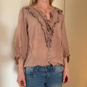 Rosa blus med detaljer - Varan är lite skrynklig men kan lösas enkelt med strykjärn. Fin somrig och luftig blus. Toppen är en längre modell.