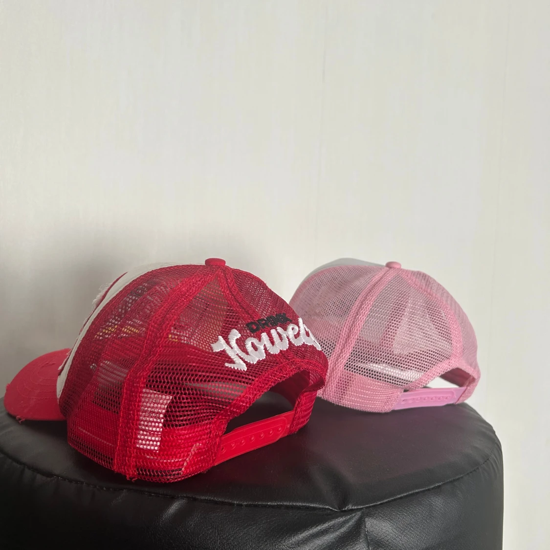 Två meshkepsar i rött och rosa