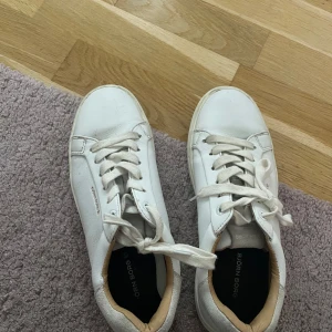Vita sneakers från Björn Borg - Stilrena vita sneakers från Björn Borg med klassisk design och rund tå. Skorna har snörning och är tillverkade i skinn med en platt sula. Perfekta för en clean och fräsch look året runt.