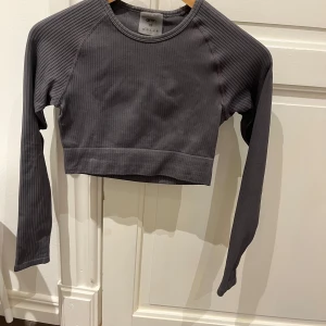 Mörkgrå croppad ribbad tröja Aim'n - Ganska kort, långärmad träningtröja från aimn. Inte mycket använd och tvättad innan försäljning. 
