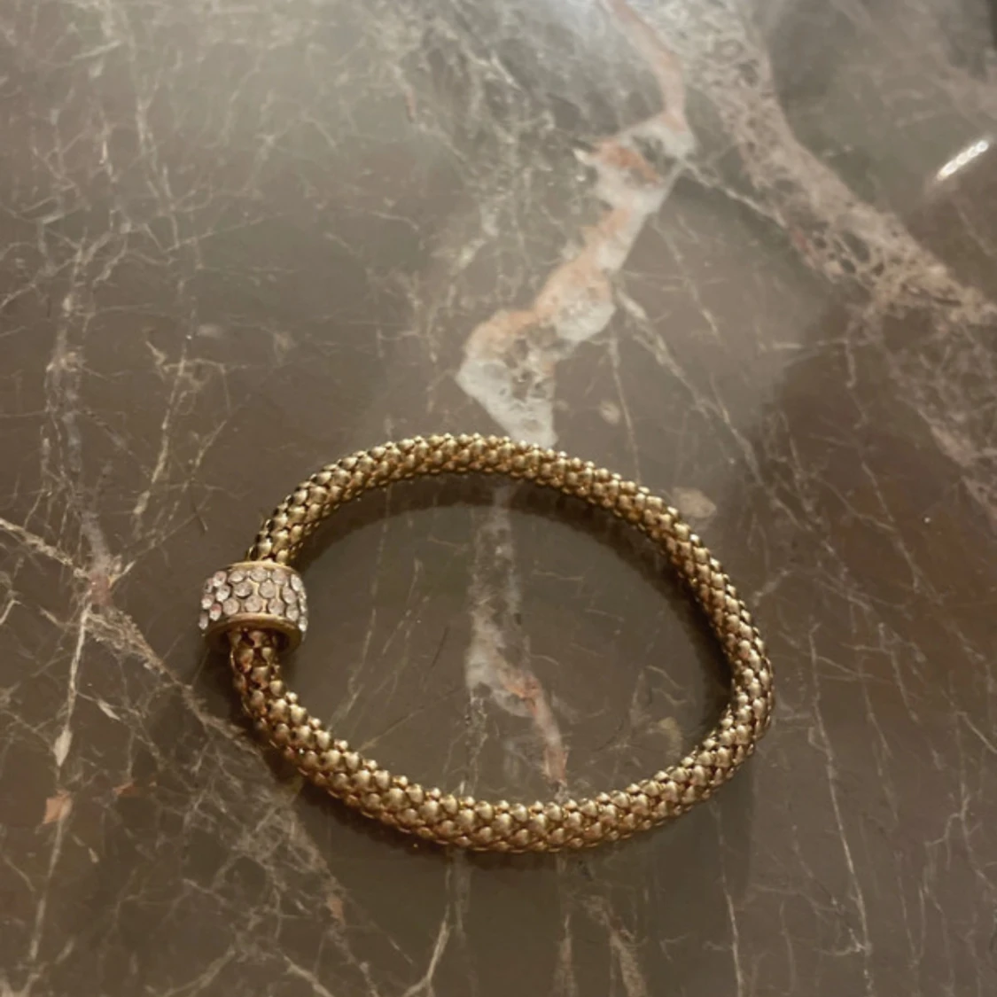 Guldigt armband med glittrig detalj - 1