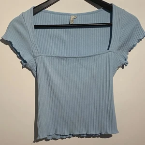  Topp!  - Jättefin Ljusblå ribbad topp med fyrkantig ringning!  Från NLY trend med ribbad struktur och fyrkantig ringning. Korta ärmar med vågig kant och croppad passform. Perfekt till jeans eller kjol för en chill look.Nyskick! Inga skador eller anmärkningar. 
