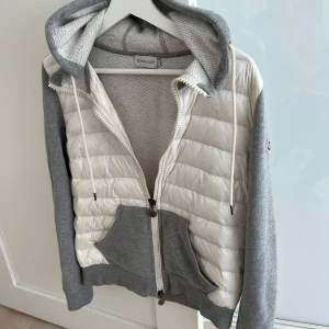 Moncler cardigan - Säljer en svin fet o fräsch Moncler cardigan i färgen grå och vit storlek s. Jackan är köpt på vongreven closet och är endast använd 1-2 gånger efter det och det finns inga defekter. Självklart äkta eftersom den är köpt från vongreven closet och har även kvitto därifrån. Bara att höra av sig vid frågor mm.
