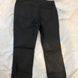 Nya Svarta coated /skinnbyxor från Weekday - Snygga svarta coated byxor från Weekday med klassisk femficksmodell och raka ben. Byxorna har bälteshällor och knappstängning. Materialet har en lätt glansig finish som ger en cool look. Perfekta att styla med sneakers eller boots. Passade ej mig! De kostar 700 egentligen!
