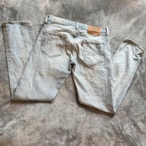 Ljusblåa Levi’s Jeans - Säljer ett par ljusblå Levi’s jeans i storleken W29/L32. Varan är i bra skick då den ända defekten är det lilla håller på bild 4. (Brodyret på den vänstra fickan är en del av designen) Om du har några frågor så tveka inte att höra av dig. Pris går att diskuteras