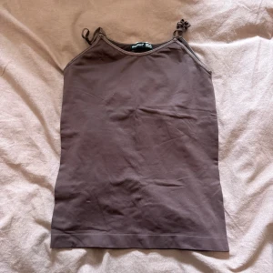 Brun linnetopp med smala axelband - En enkel och stilren brun linnetopp med smala axelband. Toppen är rak i modellen, perfekt för varma dagar eller som lager under andra plagg. Storlek M!❤️