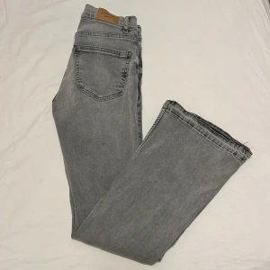 Grå jeansbyxor från Gina Tricot - Snygga grå jeansbyxor från Gina Tricot. De är bootcut med klassisk fickor. Byxorna har normal passform och är tillverkade i mjukt denimtyg. Perfekta för en avslappnad och trendig look. Skriv för mer info/bilder priset går att diskutera 