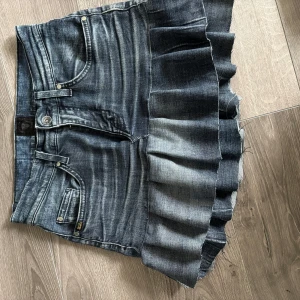 Jeanskjol med volang från Tiger of Sweden - Cool jeanskjol från Tiger of Sweden i tvättad blå denim som jag har sytt själv. Kjolen har volangdetalj nedtill som ger en unik look. Hör av er vid frågor och om ni vill ha bild på!! (Pris går att diskutera) står storlek 29/34 men är mindre i storleken och sitter som S/27