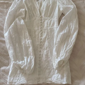 Adoore klänning - Superfin kort klänning från Adoore i modellen Florence. Bara använd på min student! Jag har sytt om någon knapp (se sista bilden), men jag kan skicka med små ”lagningslappar” man kan stryka på för att inte känna tråden