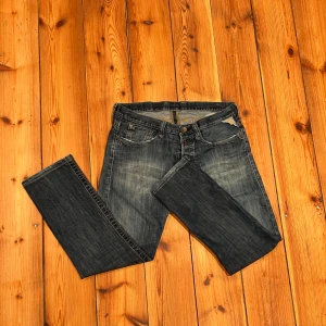 Replay blå jeansbyxor - Tja. Säljer ett par klassiska blå jeans från Replay med snyggt slitna detaljer och raka ben. Jeansen har fem fickor, knappgylf och tydlig Replay-lapp bak i midjan. Perfekta för dig som gillar en tidlös denimlook. Det är ett par gamlare jeans men bra skick. Tveka inte att höra av dig vid minsta lilla fundering 🤩✌🏻🥂