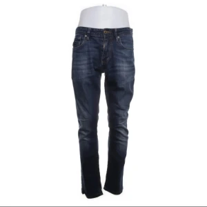 Superdry Jeans - Säljer ett par mörkblå jeans från Superdry med klassisk design.Jeansen har normal passform och raka ben. Materialet är mjukt och stretchigt tack vare bomull och elastan. Storlek 32/34