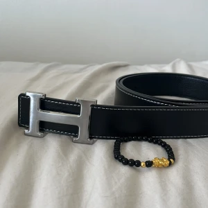 Svart bälte med silver från hemres - 115 cm. Svart bälte från Hemres. Perfekt accessoar för att lyxa till din outfit. Helt oanvänd och ren. PRISET KAN DISKUTERAS