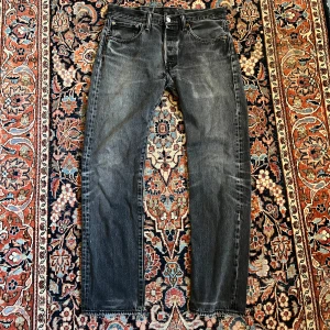 Vintage Levi’s 501 - Sjukt snygga mörkgrå jeans från Levis, dessa har en sjuk fade och en lagning vid skrevet men den syns inte när man använder dem. Midja:40 längd:102